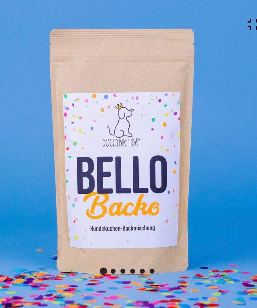 Eine Verpackung von DOGGYBIRTHDAY Bello Kuchenbackmischung auf einem Tisch mit Konfetti