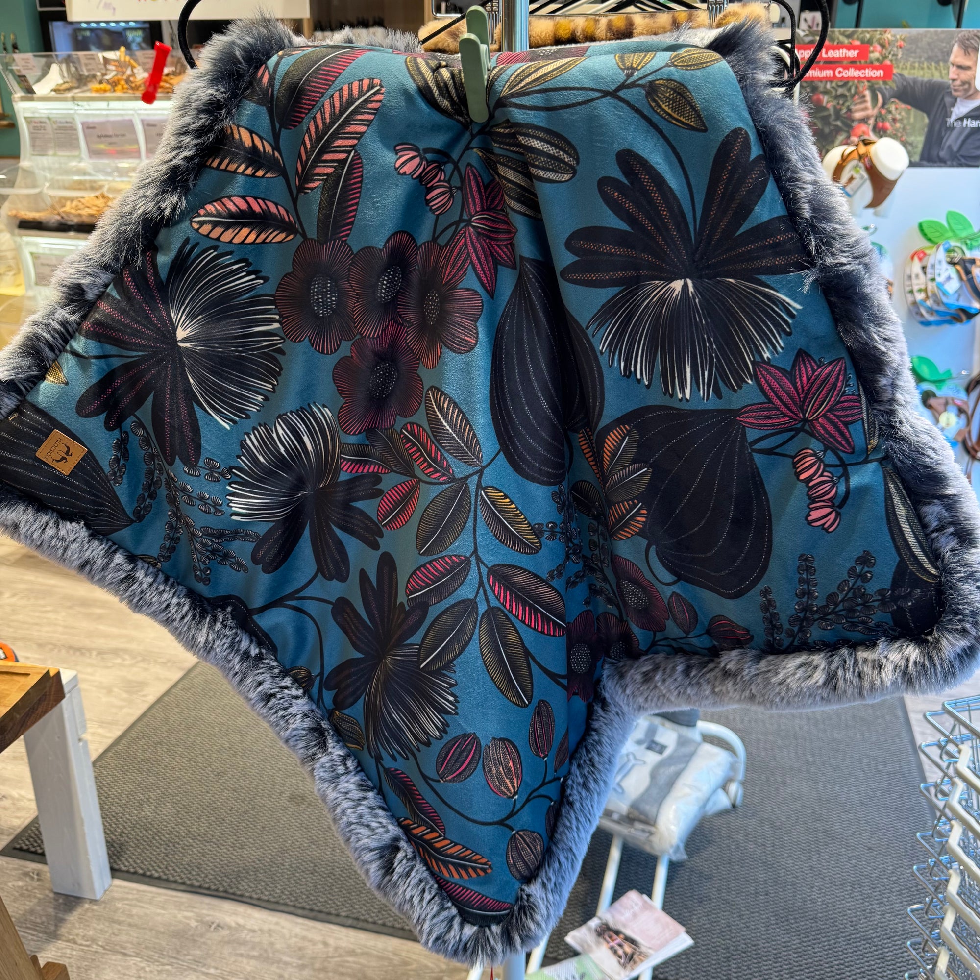 Eine Hundedecke aus blauen Samt mit Blumenmuster und Kunstfell.