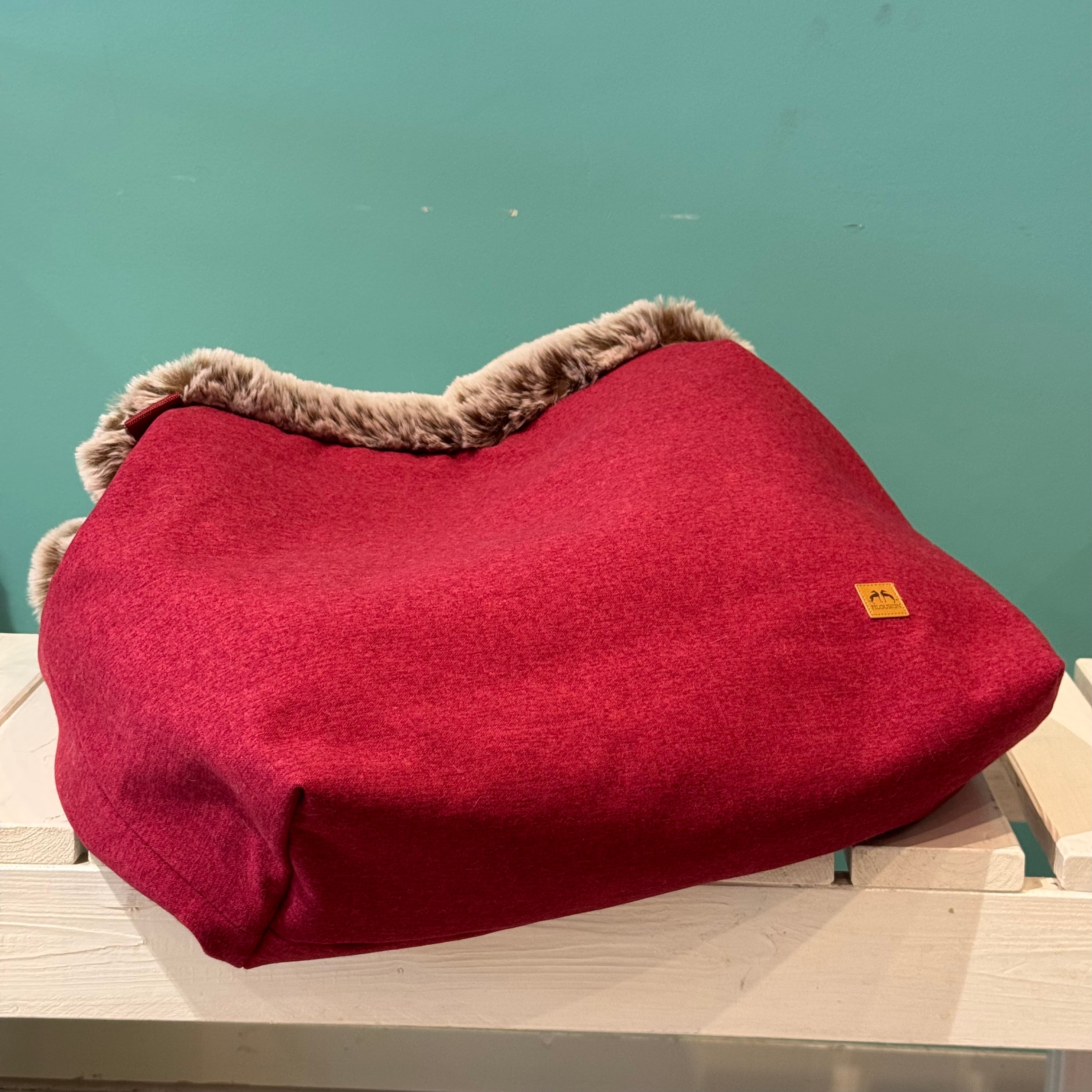Liegender Kuschelsack in Rot auf einer weißen Bank Anders positioniert 