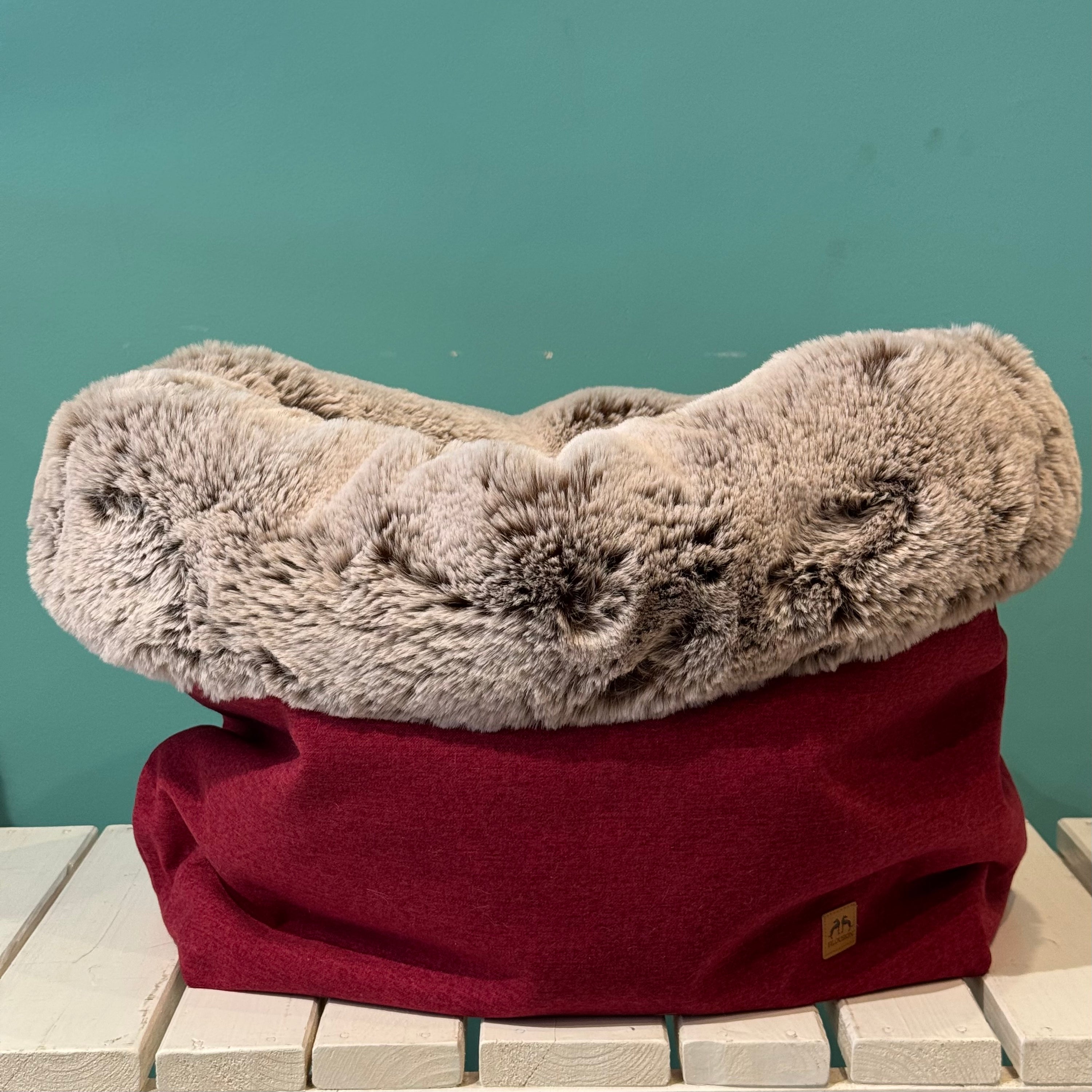 Kuschelsack in Rot auf einer weißen Bank Anders gerollt 