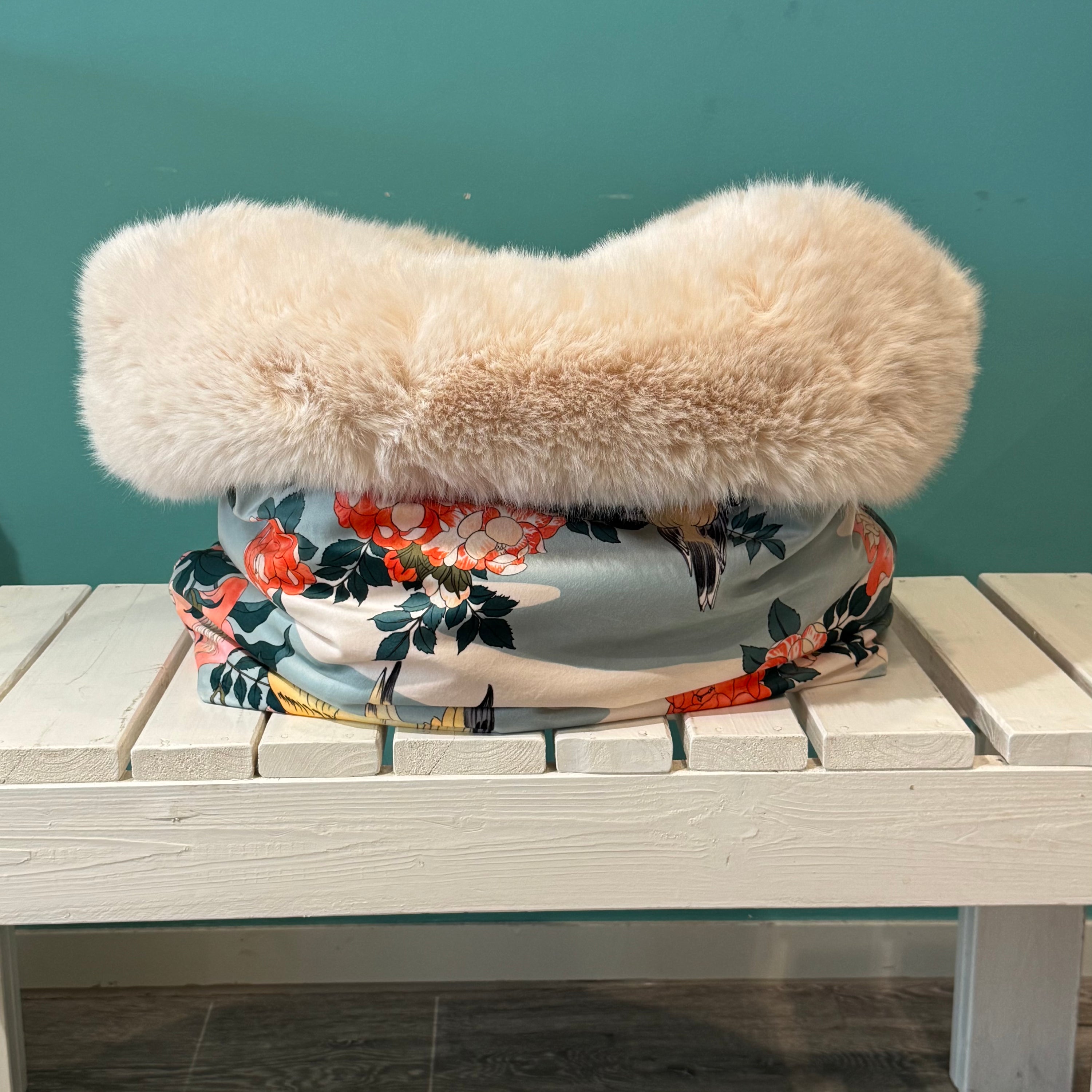Kuschelsack mit Vogelmotiv in blau weiß auf einer weißen Bank 