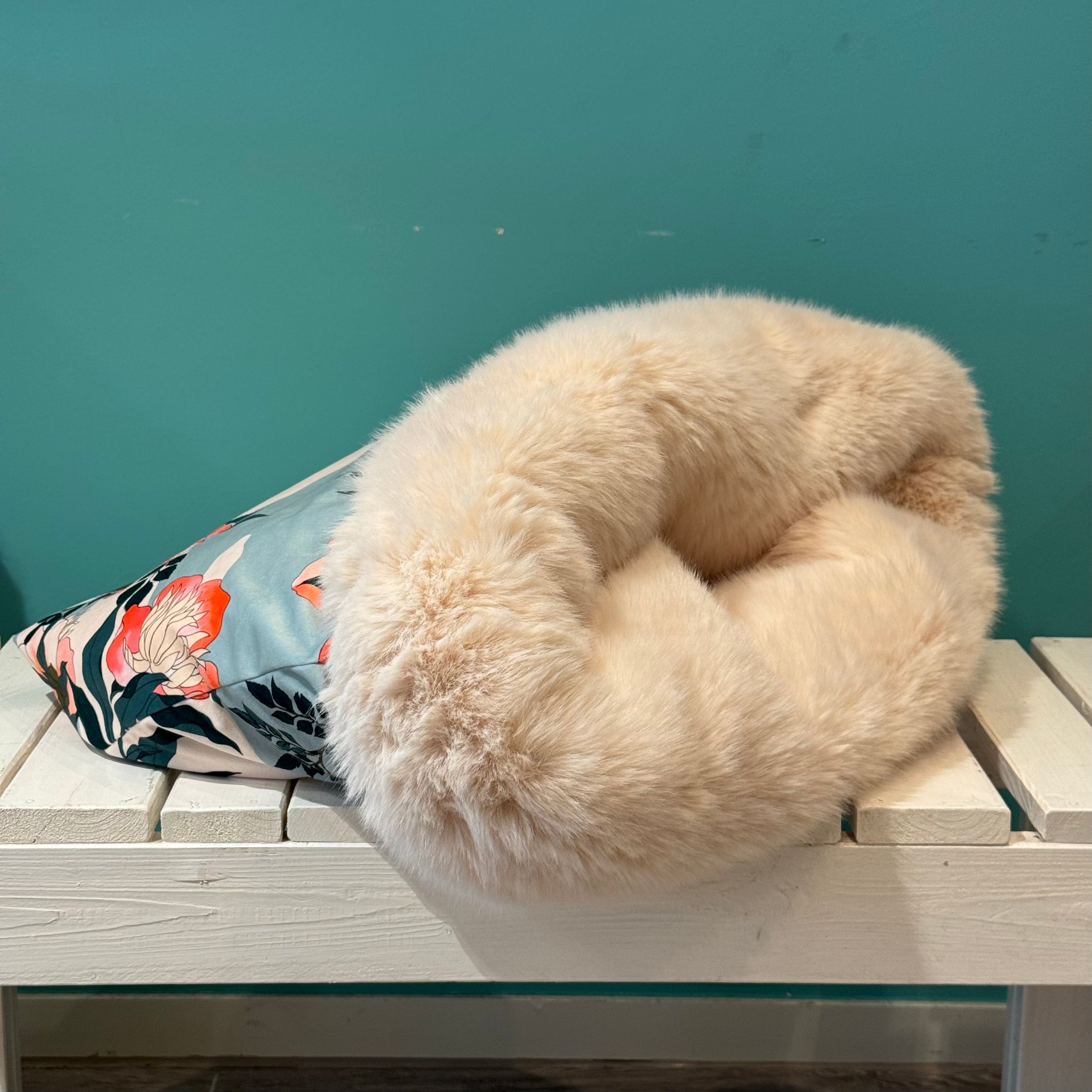 Kuschelsack mit Vogelmotiv in blau weiß auf einer weißen Bank Liegend 