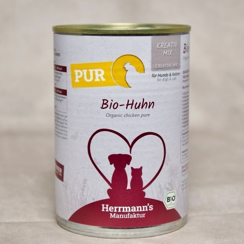 Dose Hundefutter mit Herrmanns BIo Huhn. Abbildung sitzender Hund neben sitzender Katze umrahmt von einem Herzen