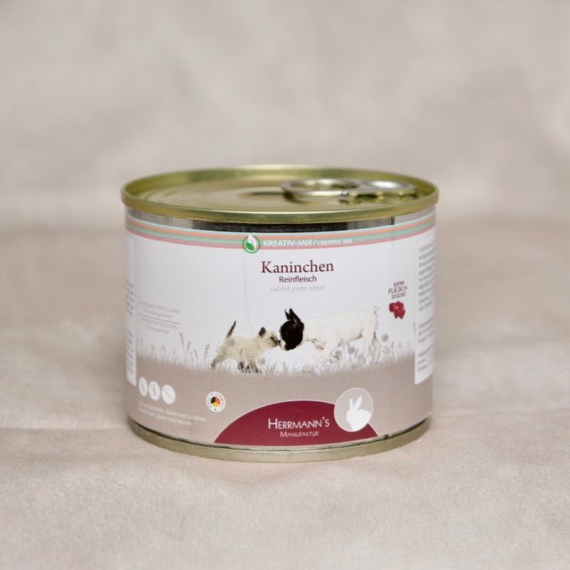 Dose Hundefutter mit Herrmanns BIo Kaninchen. Abbildung sitzender Hund neben sitzender Katze umrahmt von einem Herzen