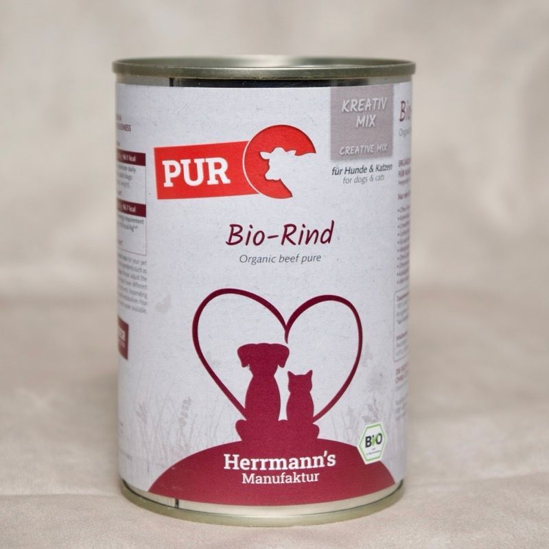 Dose Hundefutter mit Herrmanns BIo Rind. Abbildung sitzender Hund neben sitzender Katze umrahmt von einem Herzen