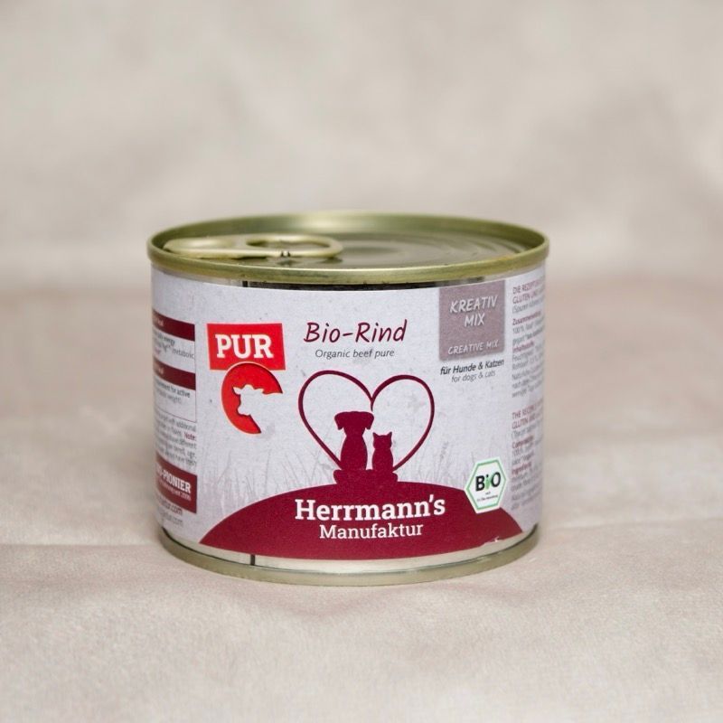 Dose Hundefutter mit Herrmanns BIo Rind. Abbildung sitzender Hund neben sitzender Katze umrahmt von einem Herzen