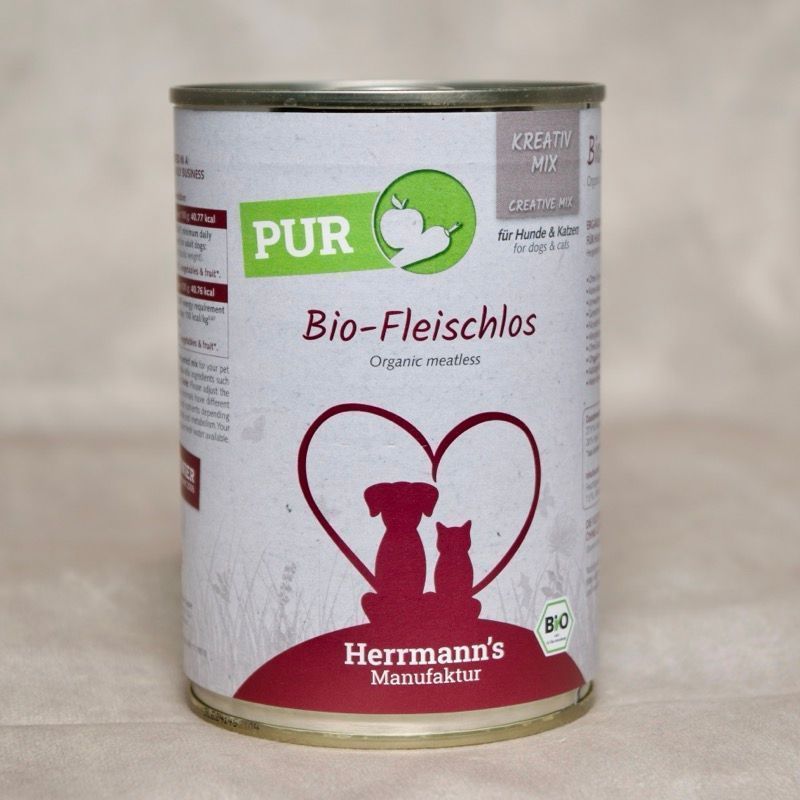 Dose Hundefutter mit Herrmanns  Bio Fleischlos. Abbildung sitzender Hund neben sitzender Katze umrahmt von einem Herzen