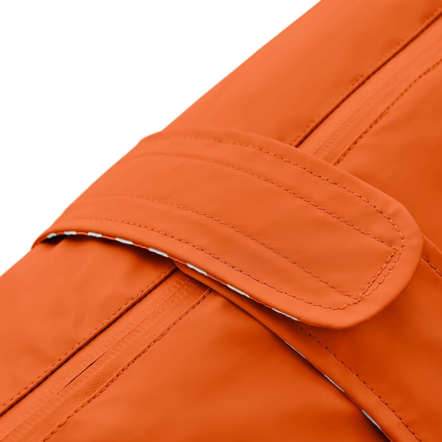 Nahaufnahme des Klettverschluss-Bereichs am orangen Hunderegenmantel.