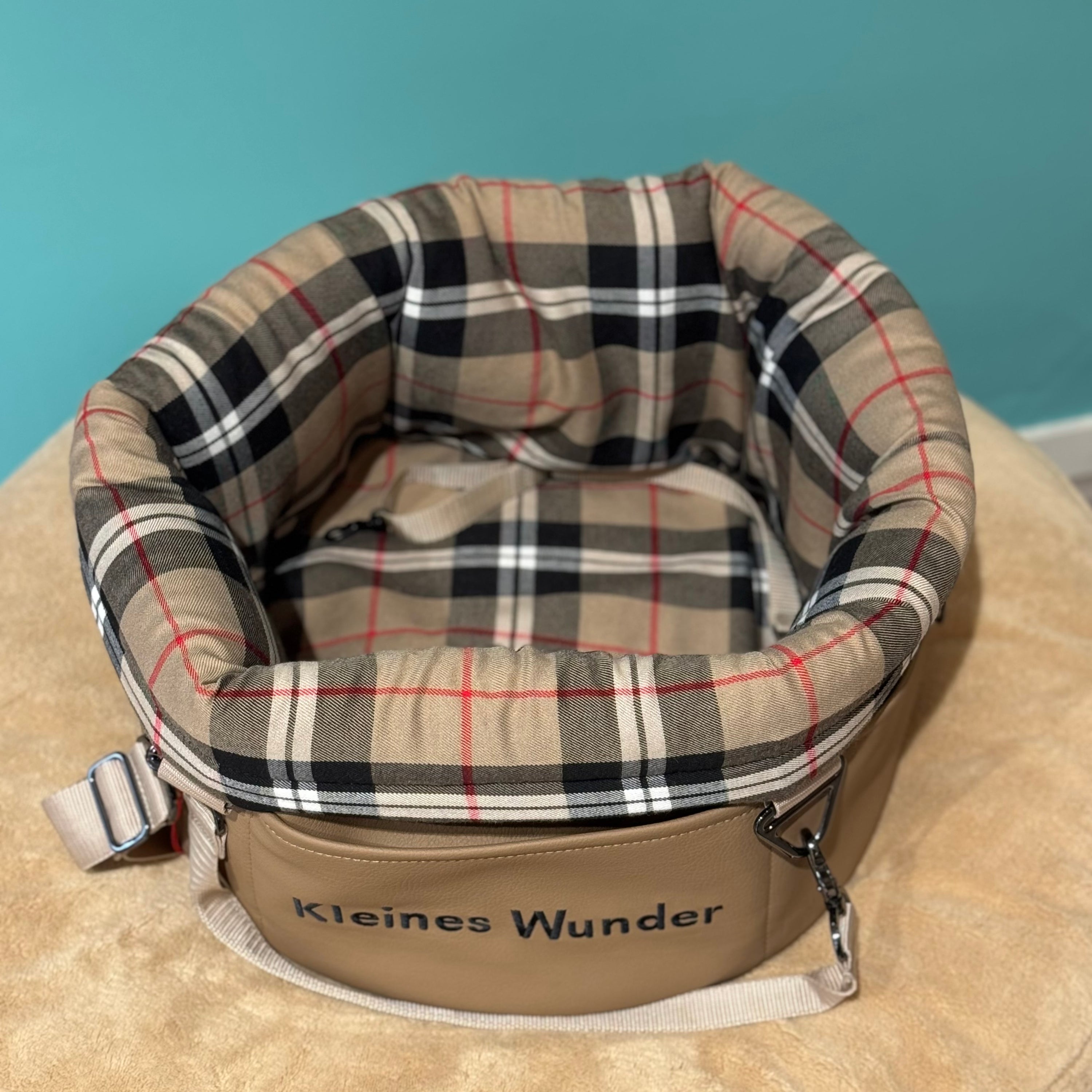 Isarhund Herzstück Tasche in Beige mit kariertem, weich gepolstertem Rand, bestickt mit Schriftzug „Kleines Wunder“, verstellbarem Schultergurt und Karabinern, komfortable Hundetragetasche für kleine Hunde. Dreausicht