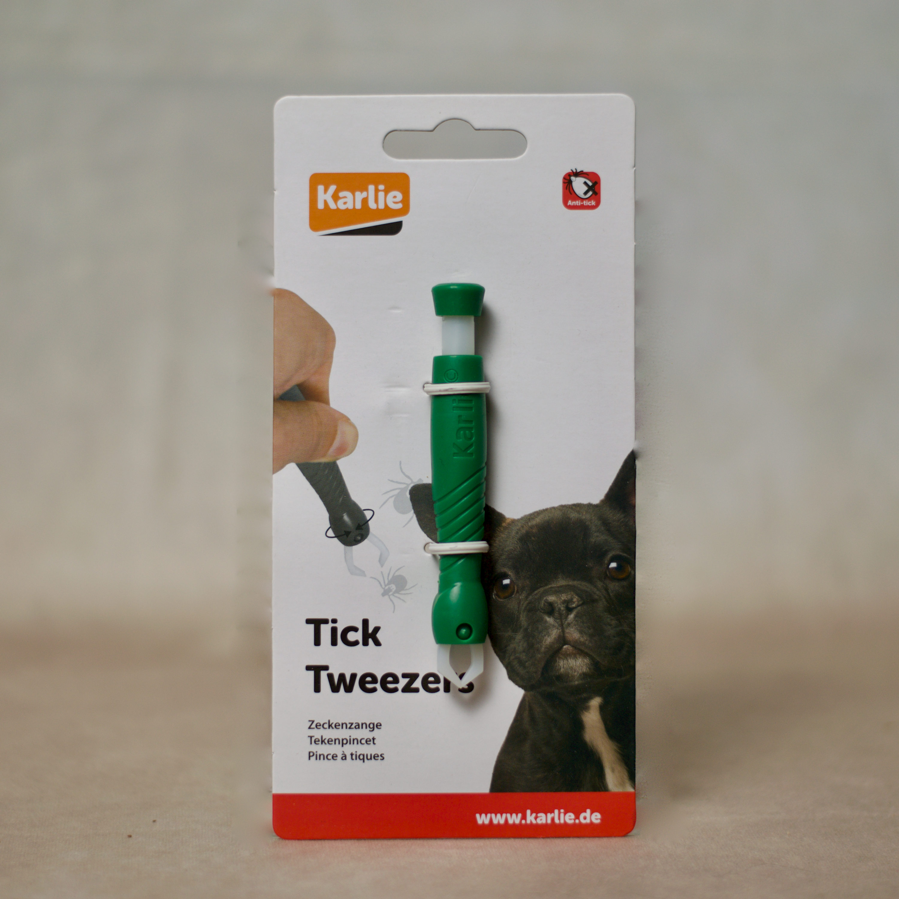 Grüne Zeckenzange von Karlie in Blisterverpackung, mit Abbildung eines kleinen schwarzen Hundes und Demonstrationsgrafik zur Anwendung