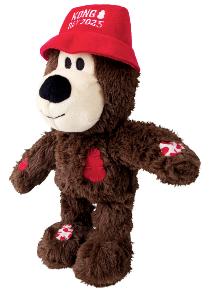 KONG Day 2025 Special Edition Plüschbär in Braun mit rotem Hut und Quietschfunktion, weiches Hundespielzeug mit aufgenähten Patch-Details. Von links
