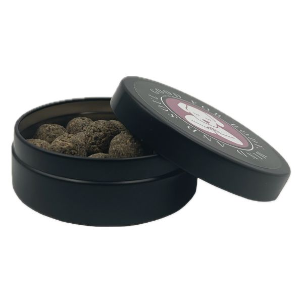 Schwarze Metalldose mit geöffnetem Deckel, gefüllt mit runden Veganer Nacani CBD Hundesnacks , hochwertiger natürlicher Belohnungssnack für Hunde.