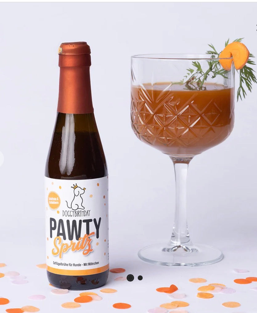 Eine Flasche mit Geflügelbrühe mit Möhren und im Glas mit weißem Hintergrund und Konfetti