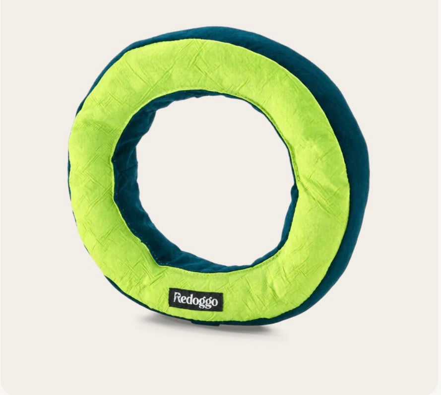 Ein Hundespielzeug in einer Donatform in den Farben Neon und Petrol 