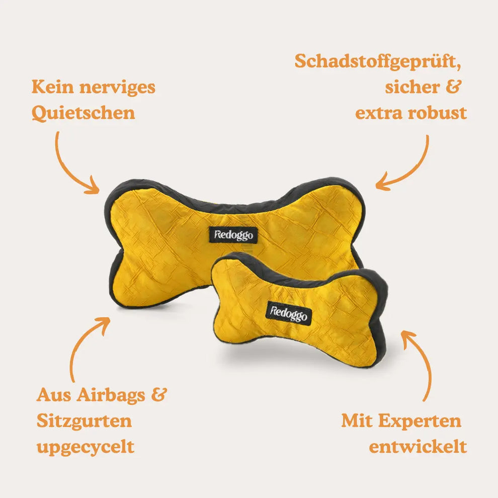 Zwei gelbe Hundespielzeugs in Knochenform mit Logo Redoggo mit Beschriftungen, die auf die Vorteile hinweisen