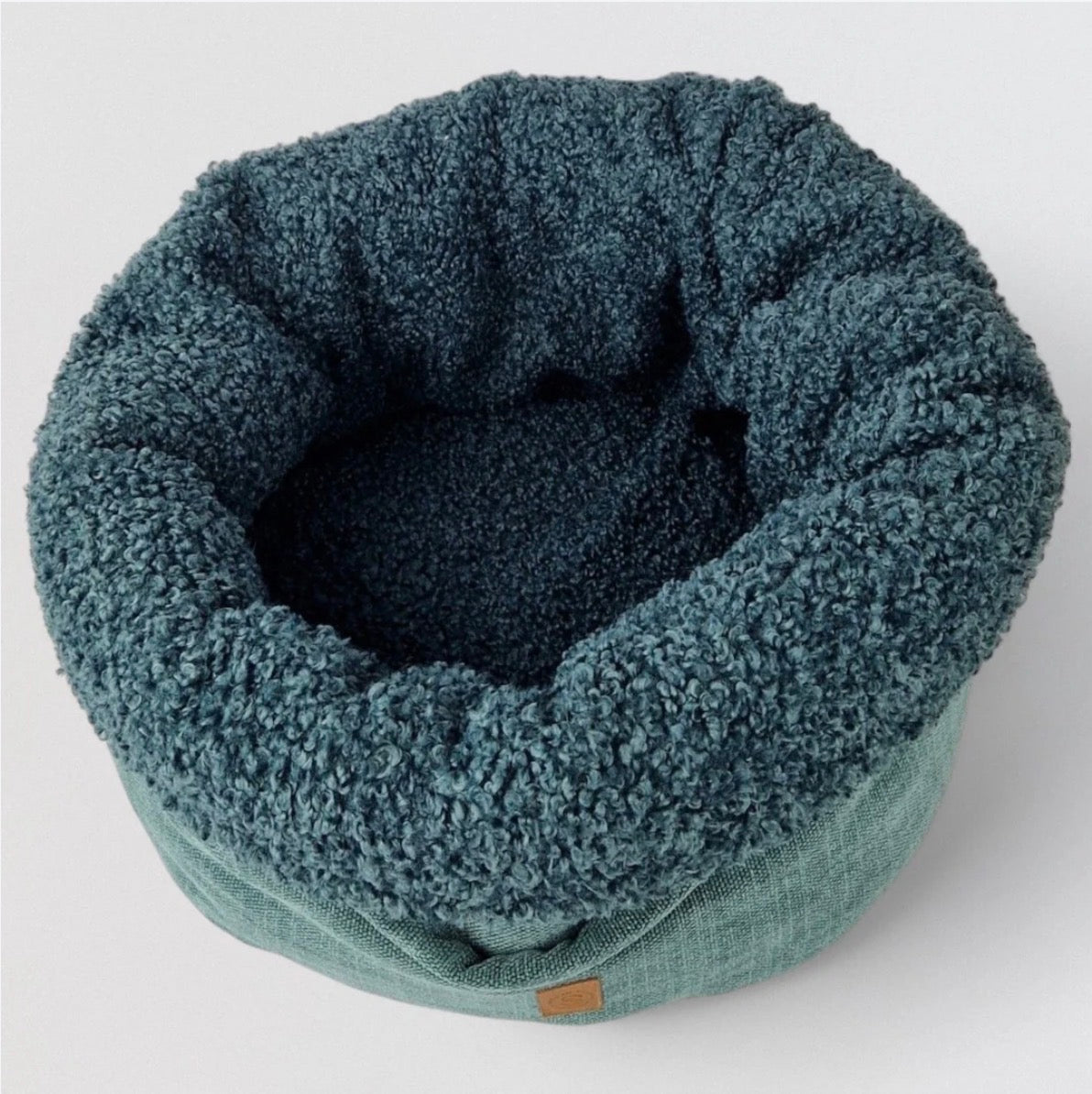 Eine Hundebett in der Farbe Petrol von oben fotografiert 