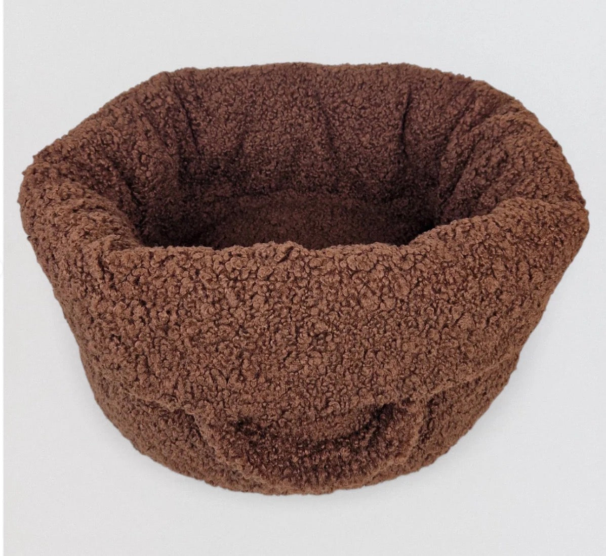 Ein kuscheliges Hundebett in Braun von oben fotografiert 