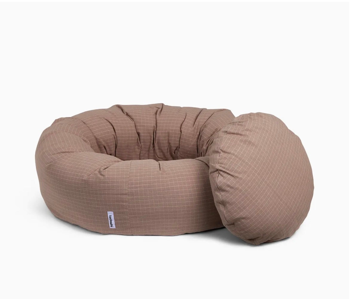 Eine Hundebett in Donutform mit einem Kissen 
