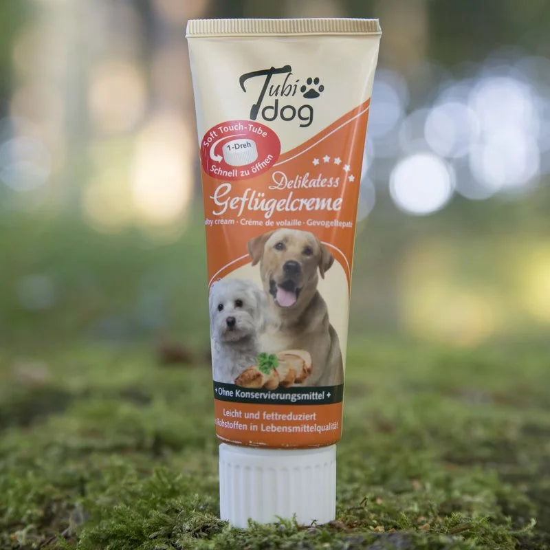 Tube mit Geflügelcreme Hundeleckerli auf Rasenfläche 