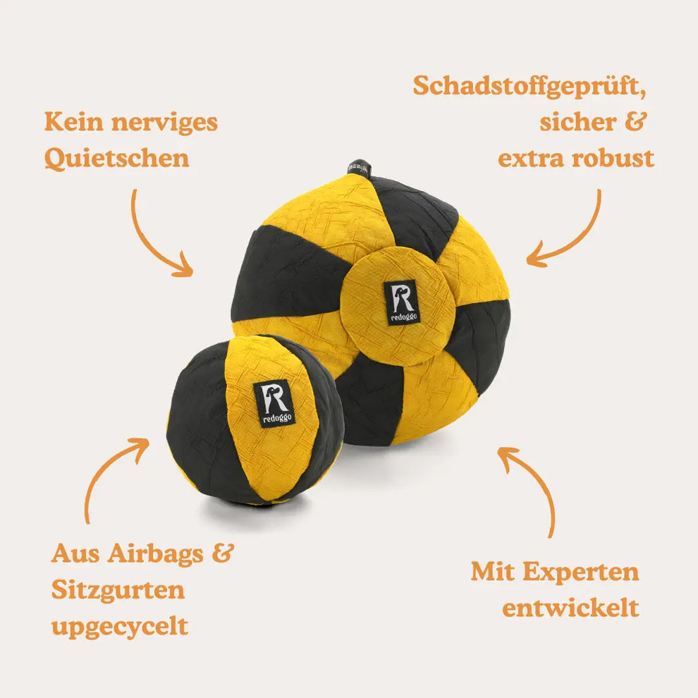 Zwei Redoggo Hundebälle in Gelb und Schwarz aus upgecycelten Airbags und Sitzgurten, schadstoffgeprüft, robust und ohne Quietschgeräusch, mit Expertinnen und Experten entwickelt.
